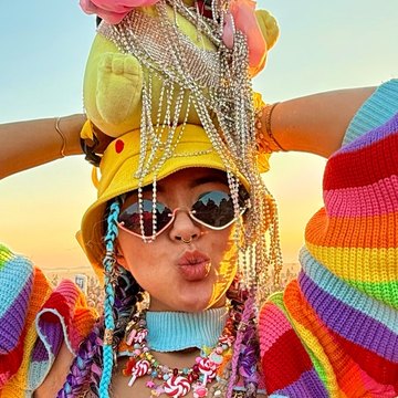 Kara Wang at Burning Man, in a Pikachu hat and rainbow knit